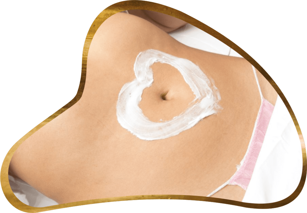 A woman with a heart shaped cream on her stomach.